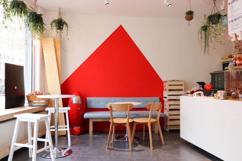 A contemporary coffee shop with a bright red triangle on a white wall