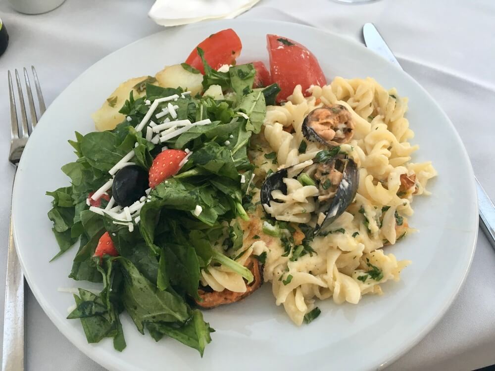 A fresh salad with pasta on a white plate