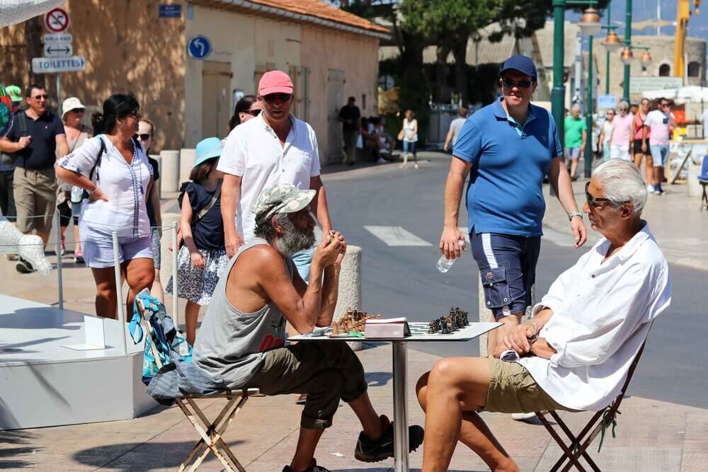 St Tropez - couple sat in street on metal chairs