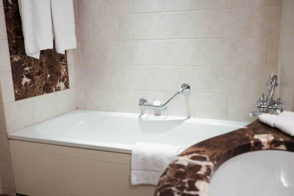 Corinthia Budapest - Bath with handle, ceramic cream tiles